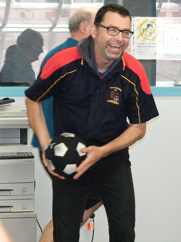Picture of a man holding a soccer ball as though he is about to throw it.